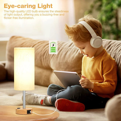 Child using tablet next to Bedside Table Lamp With 3 Way Dimmable Touch Control, USB C Charging Ports And AC Outlet, wood base, flaxen shade.