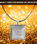A square pendant from the DIY Necklace Making Kit With Base Tray Pendant Molds And 60pc Metal And Plastic Accessories displayed on a sparkly gold background.