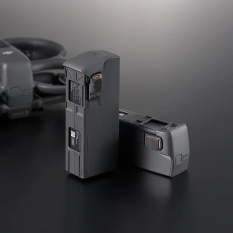 Two DJI Avata 2 Intelligent Flight Batteries deliver about 23 minute flight time for DJI Avata 2 FPV drone on a dark surface.