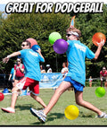 Two people playing dodgeball outdoors using 10 Inch Kickball Playground Balls - (Pack of 6) Inflatable Rubber Indoor Outdoor Bouncy Balls.
