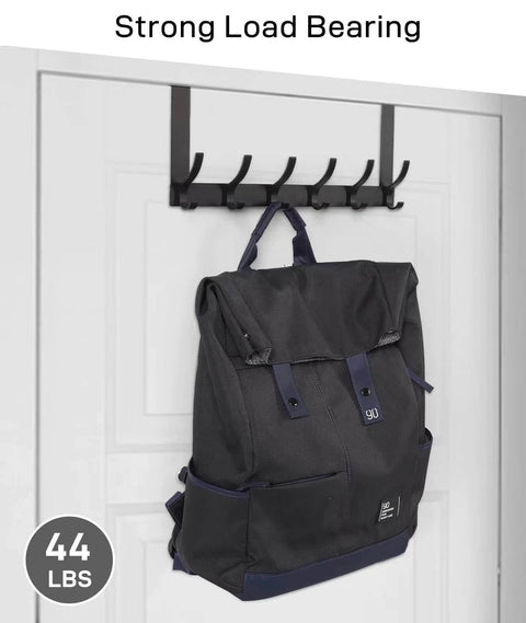 Backpack hanging on a black wall hook with strong load bearing 44 lbs; hooks installed on a white door.