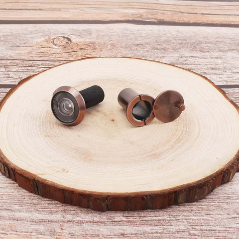 Heavy Duty 200 Degree Door Peephole Viewer with Rotating Privacy Cover, brushed antique copper finish on wooden background.