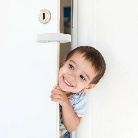 Child smiling near door with Door Pinch Guard Baby Door Stopper 6 Pack Soft Foam Keeps Tiny Fingers Safe and Doors From Slamming installed