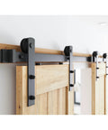 8FT Double Barn Door Hardware Kit for Two 24 Inch Door Panels with carbon steel sliding track and nylon rollers, installed view.
