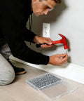 Man installing baseboard with red hammer and 400 pcs double headed skirting nails with sleeve tools for solid wood baseboards
