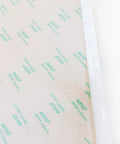 Close-up of 468MP Double Sided Adhesive Transfer Tape Sheets 12 By 12 Inches, pack of 5, showing protective layer and adhesive grid.