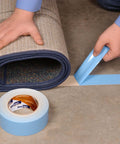 Person using Double-Sided Carpet And Duct Tape With Blue Liner Sticks To Hardwood, Concrete And Tile For Seam, Hold And Secure Carpets, Rugs And Pad; 48mm Wide By 33 Meters, Heavy-Duty Tape, Easy To Tear And Remove With No Residue, 1 Roll on carpet