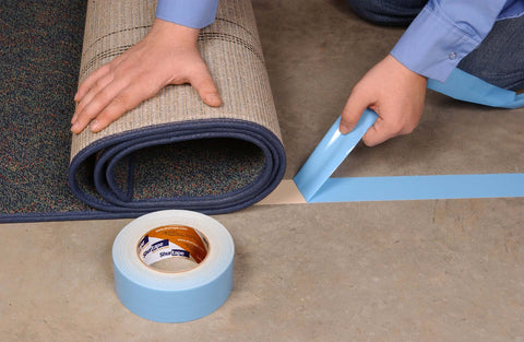 Person using Double-Sided Carpet And Duct Tape With Blue Liner Sticks To Hardwood, Concrete And Tile For Seam, Hold And Secure Carpets, Rugs And Pad; 48mm Wide By 33 Meters, Heavy-Duty Tape, Easy To Tear And Remove With No Residue, 1 Roll on carpet