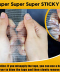 Person holding heavy duty double sided mesh tape showing sticky 2 Packs Heavy Duty Double Sided Mesh Tape 66 Feet Set Featuring 2 Inch And 1 Inch Gauze Fiberglass Tape Adhesive For Carpets And Pictures Mounting Industrial Grade Mesh For Super Sticky Grip.