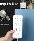 Person using Heavy Duty Double Sided Tape Roll Set to mount power strip on cabinet, includes clear wall mounting tape and removable poster tape