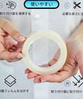 Person holding Heavy Duty Double Sided Mounting Tape Nano Adhesive Strip For Posters And Art, Clear Transparent Sticky Wall Hanger.
