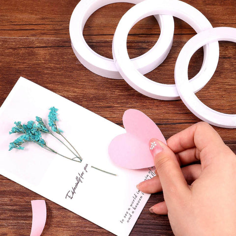 Ultra Thin Double Sided Craft Tape For Card Making Scrapbooking Gift Wrapping And Office And School Use Tear By Hand With Paper Backing Four Rolls One Quarter Inch By Thirty Two Yards Per Roll, shown with crafting materials on a table.