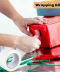 Person using 2 Inch By 40 Yards Double Sided Tape For Crafts And Scrapbooking Clear Strong Adhesive With Easy Tear Paper Backing on gift