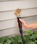 Hand installing Drip Irrigation Pressure Regulator 25 PSI For Garden Hoses And Drip Lines on outdoor faucet