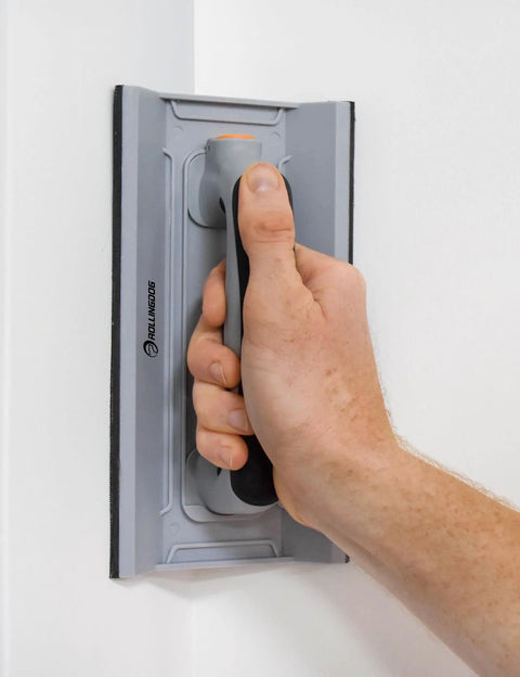 Person using Drywall Corner Sander Kit With Two Sided Pad And Six Sandpapers Included to smooth a wall corner