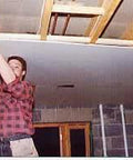 Man using ✝️ Drywall Fitting Tool, Supports The Board in Place While Installing, ensuring stability and alignment in construction.