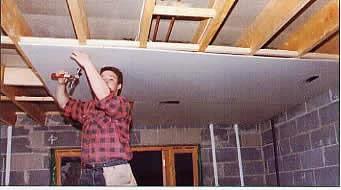 Man using ✝️ Drywall Fitting Tool, Supports The Board in Place While Installing, ensuring stability and alignment in construction.