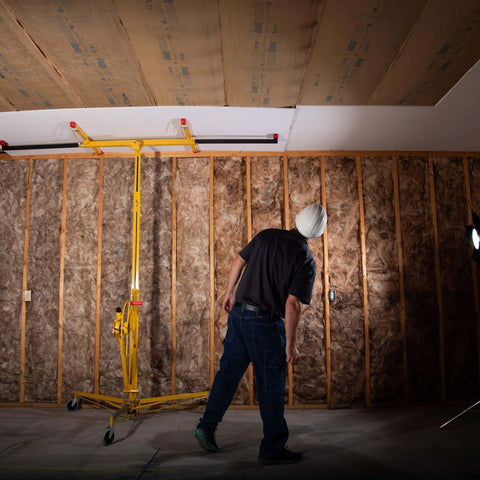 Worker using ✝️ Drywall Lift, The Original, Professional-Grade Sheetrock Hoist 138-2, 150 lbs, Rolling Panel Lift for ceiling installation