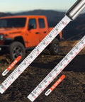 Pencil Tire Pressure Gauge 2 Pack With 16 Tire Caps Calibrated To ANSI B40.1 Grade B(2%), close-up view, off-road vehicle in background.