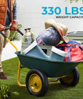 Dual Wheel Home Utility Yard Wheelbarrow Garden Cart with Built In Stand loaded on grass with gardening tools and supplies