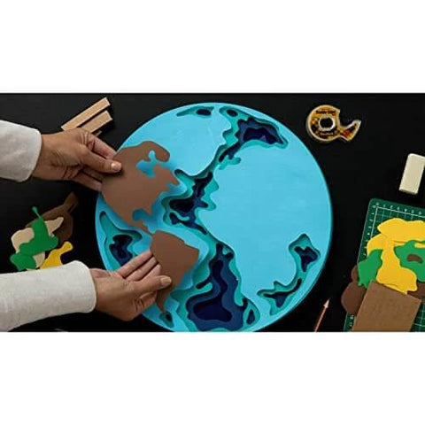 Hands assembling a globe puzzle with brown pieces on a table with scissors and tape. Product in the background is Double Sided Tape For Gift Wrapping And Crafts, Snaps On Quick For Holiday Gift Wrap, Bags, Scrapbooking And School Projects, 0.75 Inch Wide By 1296 Inch Length, Two Refill Rolls For Clean, Mess Free Bonding.