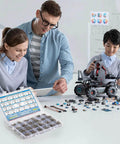 Children and teacher assembling robot with electronic components and kit on table.