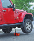 Red SUV lifted by Electric Car Jack Kit With Hydraulic Lift And Dual Power Mode, Bright LED Light, And Built In Tire Inflation