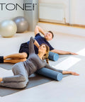 Two people using High Density EPP Foam Exercise Roller For Yoga Pilates Stretching Massage And Recovery 36 Inch Black for myofascial release.