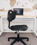 Side view of Table Height Chair Stool Deluxe Ergonomic Polyurethane Chair with 5 Inch Height Adjustment in an office setting