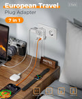 European Plug Adapter USB C 2 Pack with 4 Outlets and 3 USB Chargers in use on a bedside table charging multiple devices in a hotel room.