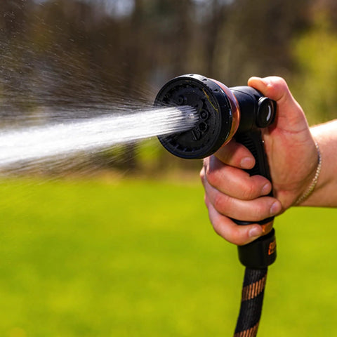 Person using Expandable Garden Hose Copper Bullet With Ten Pattern Thumb Spray Nozzle As Seen On TV 650 PSI Lead Free, spraying water