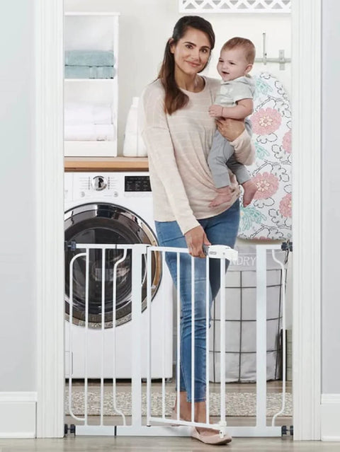 Woman with baby standing by Extra Wide Baby Gate For Doorways And Bottom Of Stairs Adjustable From 29 To 38 Inches 30 Inches Tall With 6 Inch Extension