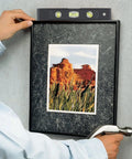 Person using 89-Piece Black Household Tool Set With 12 Pocket Tool Bag for hanging a picture frame.