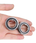 Person holding two Flanged Ball Bearing F6804-2RS 20x32x7mm, double sealed chrome steel bearings with GCr15 races and rubber seals.