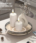 Italian natural travertine lazy susan turntable for table top, 10 inch round stone tray organizer with black frame displayed with candles.