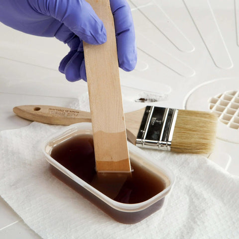 Mixing resin and hardener with a wooden stirrer from an All-In-One Fiberglass Repair Kit With Resin, Hardener, Cloth, And Tools For Automotive, Marine, And Home DIY Repairs - 0.45 Pint Waterproof Quick Fix Solution.