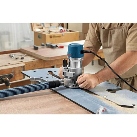Person using Fixed Base Router 2.25 HP 12 Amp Variable Speed 8000 to 25000 RPM for precise edge work on wood panel.
