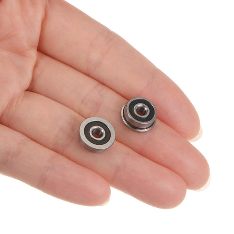 Two Flanged Ball Bearing 3x10x4mm F623 2RS Double Sealed held in a hand, showcasing chrome steel material.