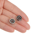 Hand holding two Flanged Ball Bearing F6232RS 3x10x4mm Double Sealed Chrome Steel ABEC1 Bearings, showing rubber seals.