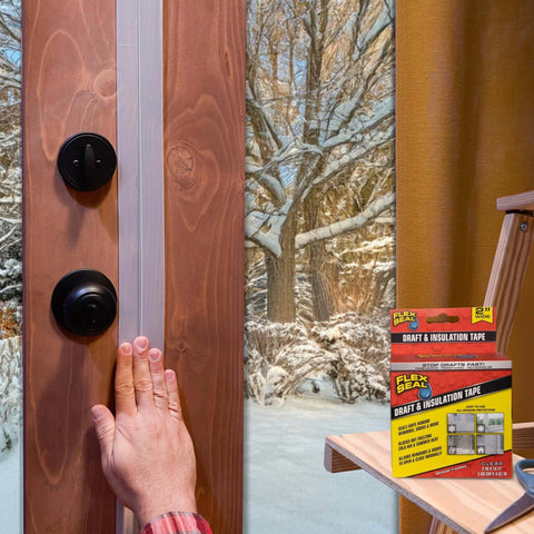 Applying Flex Seal Draft and Insulation Sealing Tape, 2 in x 16 ft, to a wooden door, with product box visible, snowy window view.
