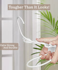 Space saving 50 pack slim plastic hanger being bent, demonstrating durability and strength in a home setting.