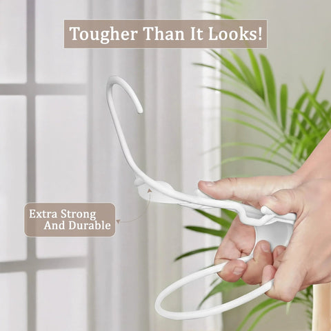 Space saving 50 pack slim plastic hanger being bent, demonstrating durability and strength in a home setting.