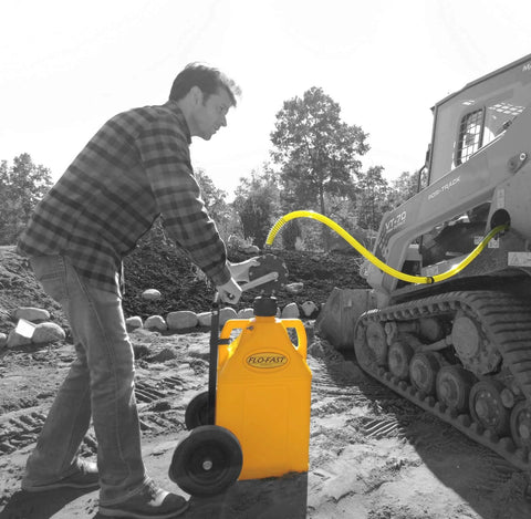 Man using FLO-FAST Pro Pump, 8GPM, Telescoping Draw Tube to transfer fluid to vehicle in outdoor construction setting