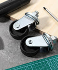 2 Pcs Floor Jack Casters For 4 Ton Floor Jack With Cast Iron Construction And 16mm Stem on a workshop table with tools.