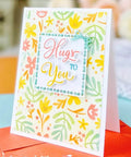 Colorful handmade card with 'Hugs to You' message, featuring floral design using Rectangular Frame Metal Die Cuts Set for Scrapbooking.