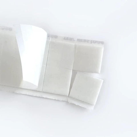 Close-up of Teacher Tape Pads Double Sided Removable Foam Tape For Wall Mounting 96 Pieces Per Pack with easy peel corner.