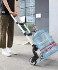 Person using folding aluminum hand truck cart 180 lb capacity portable travel dolly to move water bottle