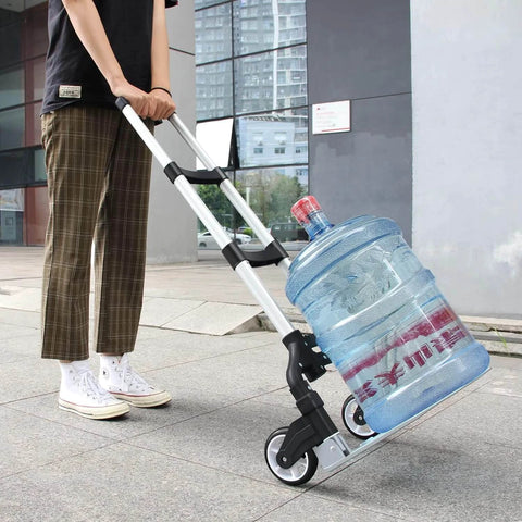 Person using folding aluminum hand truck cart 180 lb capacity portable travel dolly to move water bottle