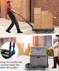Two people using a Folding Hand Truck 500lb Capacity With 6 Wheels Collapsible Luggage Cart and Elastic Ropes for transporting boxes.