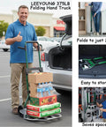 Man using Upgraded Folding Hand Truck Dolly Cart Heavy-Duty 375lb in parking lot with groceries, showing folding capability and storage options.